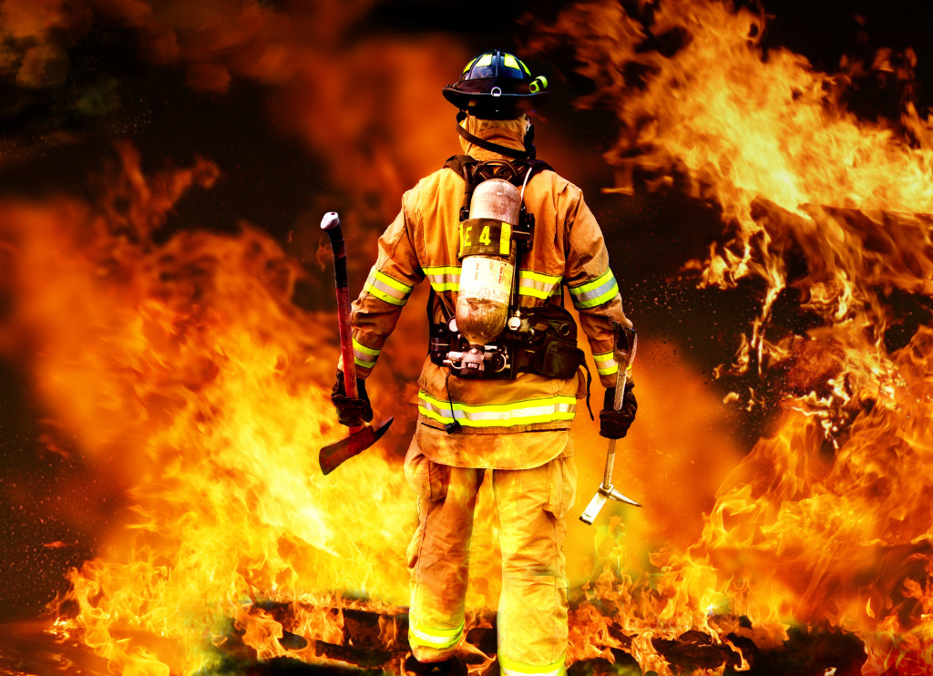 Firefighter standing in front of an ongoing fire.