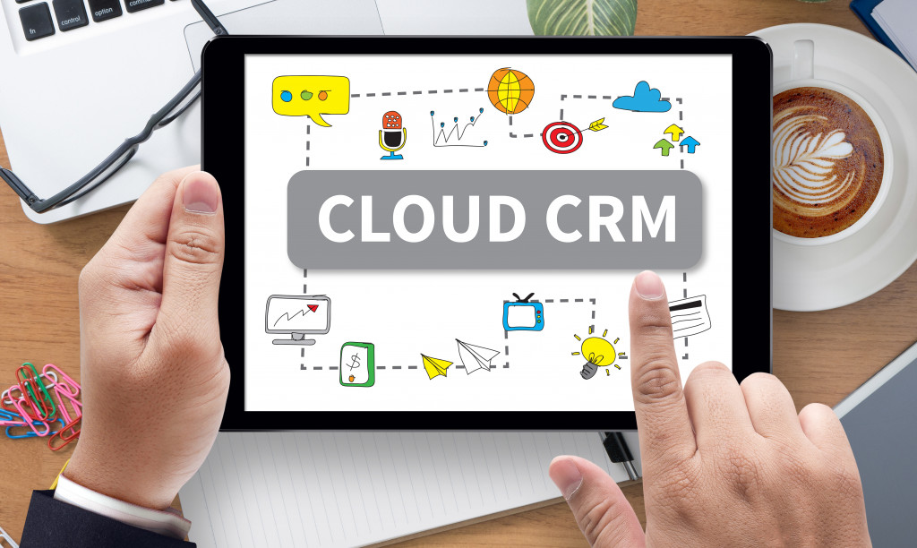 hand touching cloud CRM in tablet