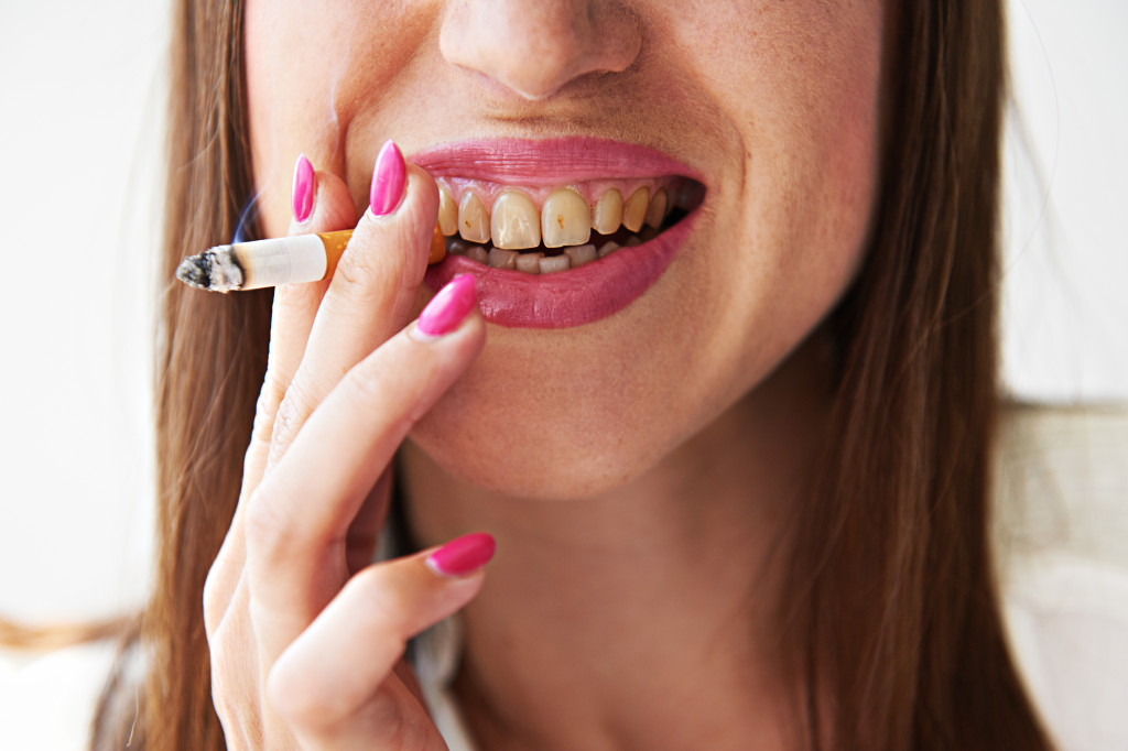 Woman with stained teeth smoking