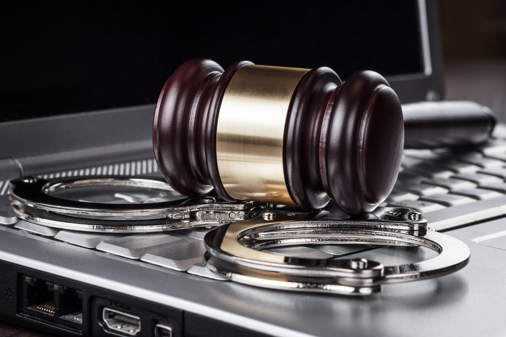 Gavel and handcuffs on top of laptop